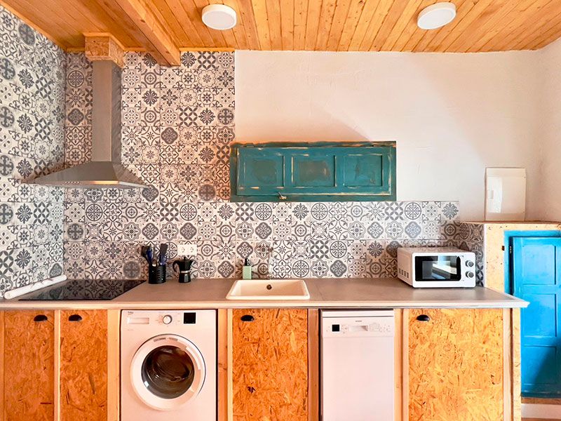 Cocina completa con fregadero, lavadora, cocina y campana extractora