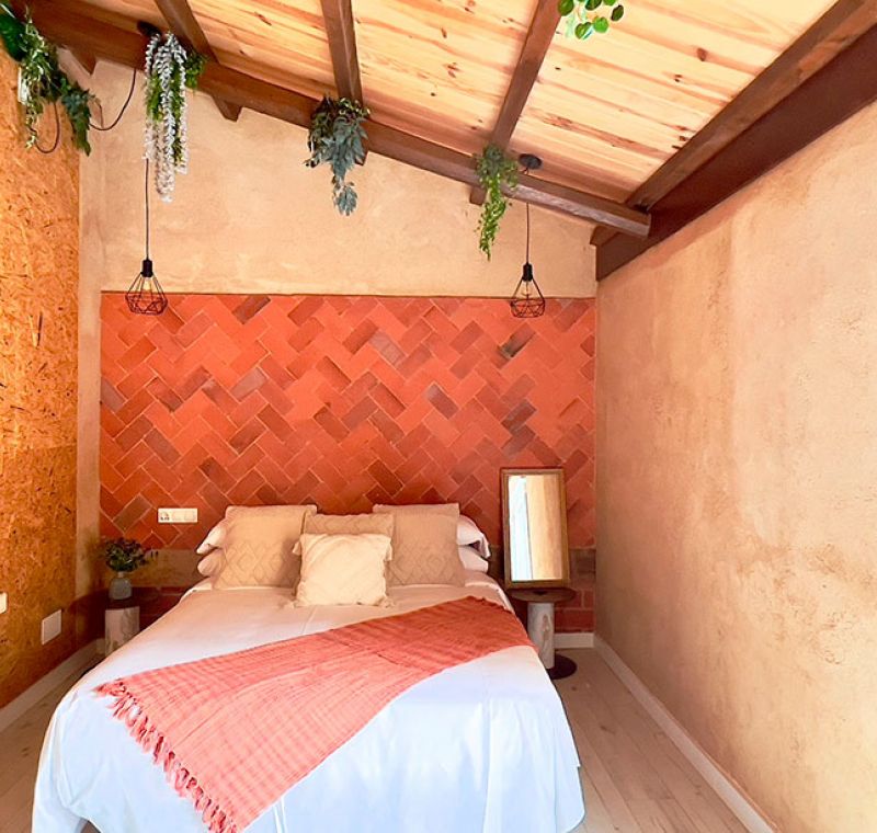 Cama de matrimonio con cabecero de azulejo en dúplex