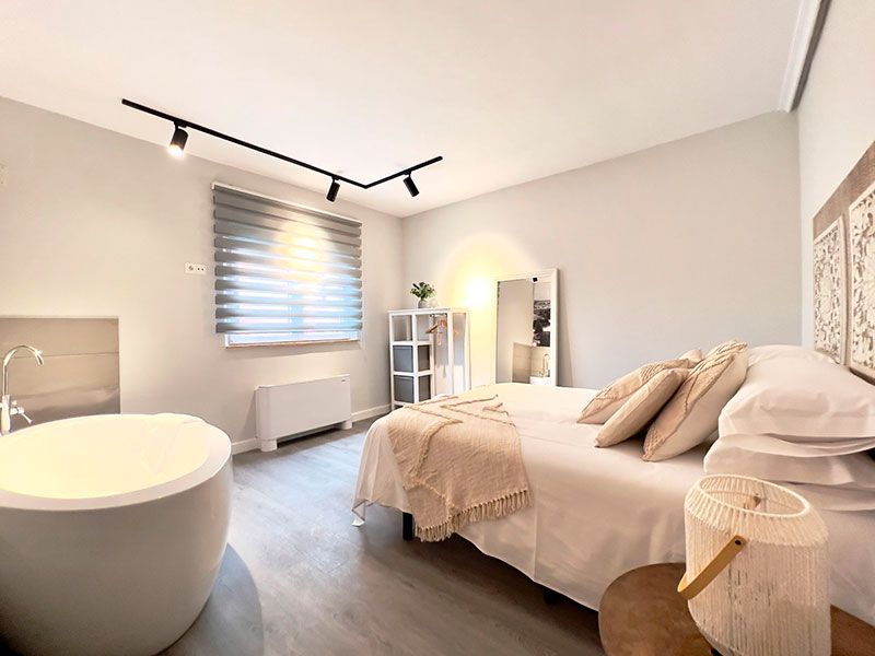 Dormitorio con cama de matrimonio y bañera redonda