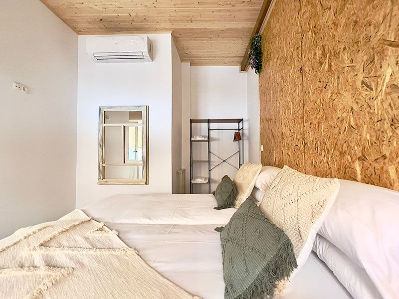 Dormitorio con cama doble con acabados en madera