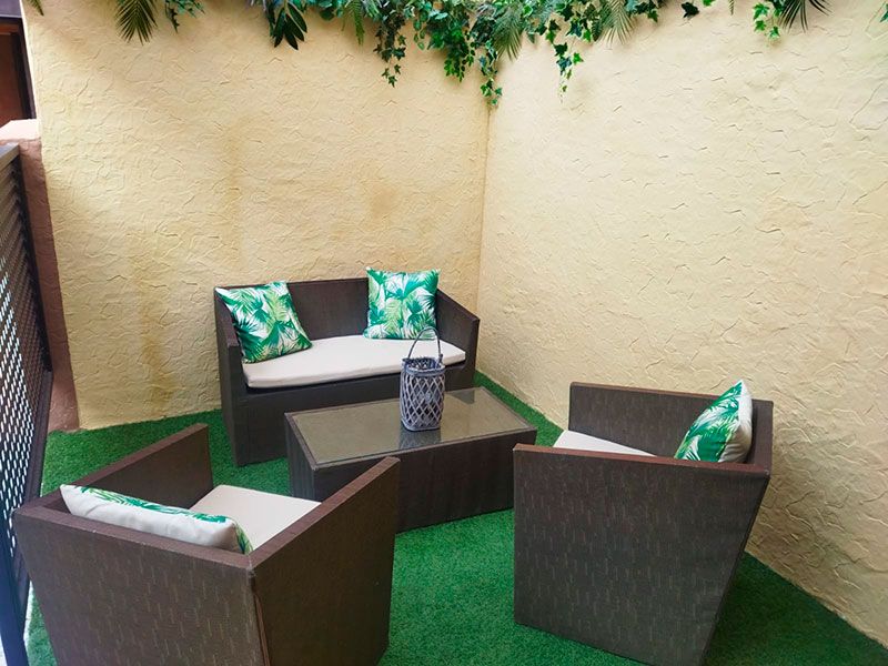 Terraza exterior con mesita gris y sofá a juego