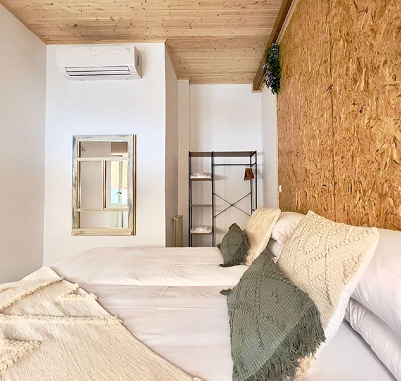 Dormitorio con cama doble con acabados en madera